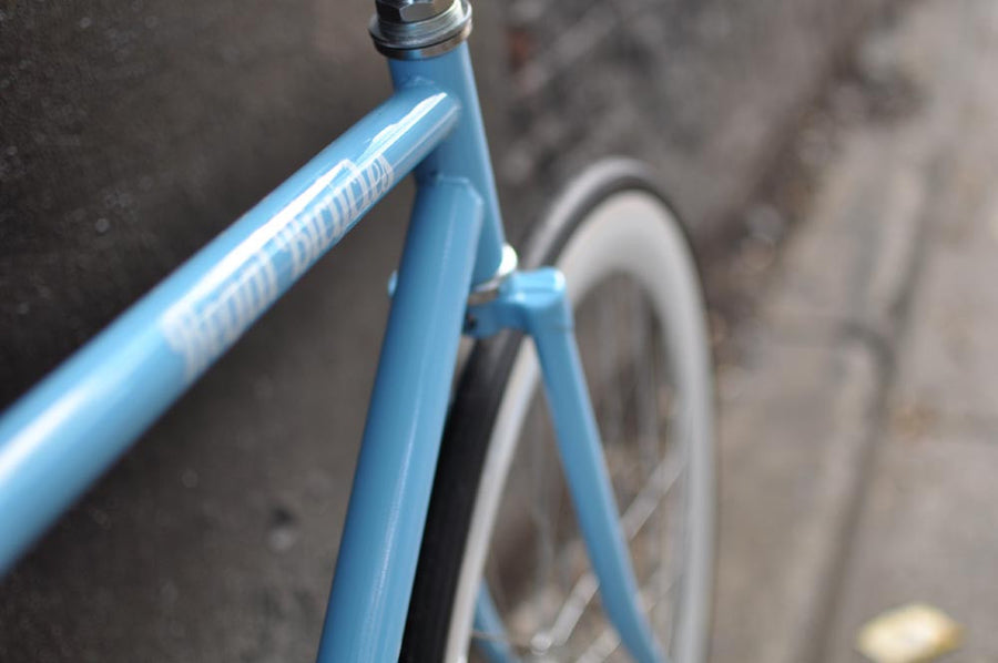 This fixed gear bicycle is called "The Prince" and features white rims and a sky blue frame.