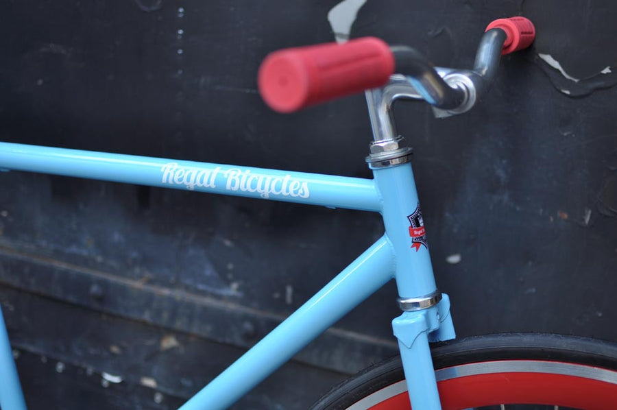 This fixed gear bicycle is called "The Maquis" and features red rims and a sky blue frame.